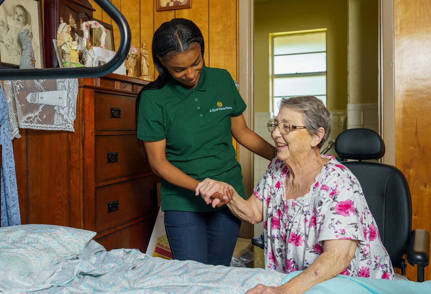 Caregiver assisting woman into bed